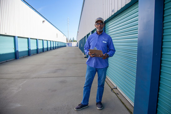 Service representative in front of self storage containers with blue doors
