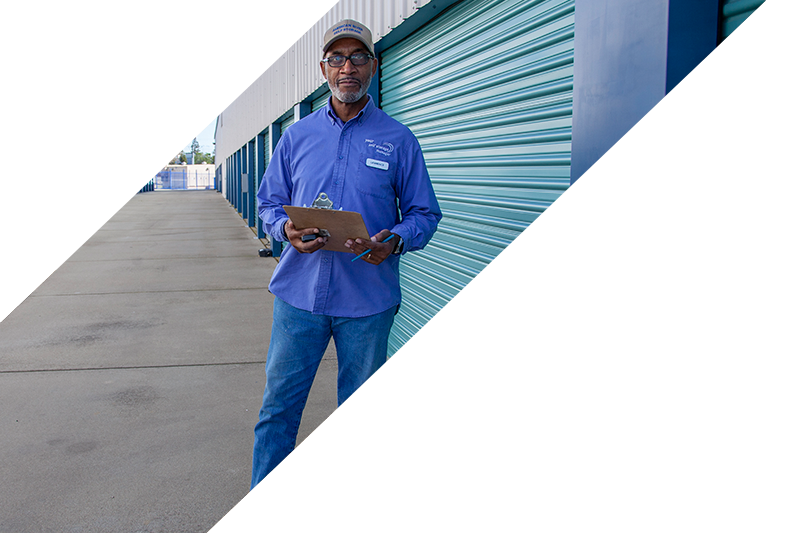 slash-people-outside Service Representative in holding clipboard in front of storage containers