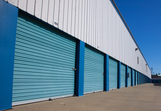 Service representative in front of self storage containers with blue doors